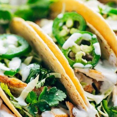 Ancho Chicken Tacos in basket with limes.