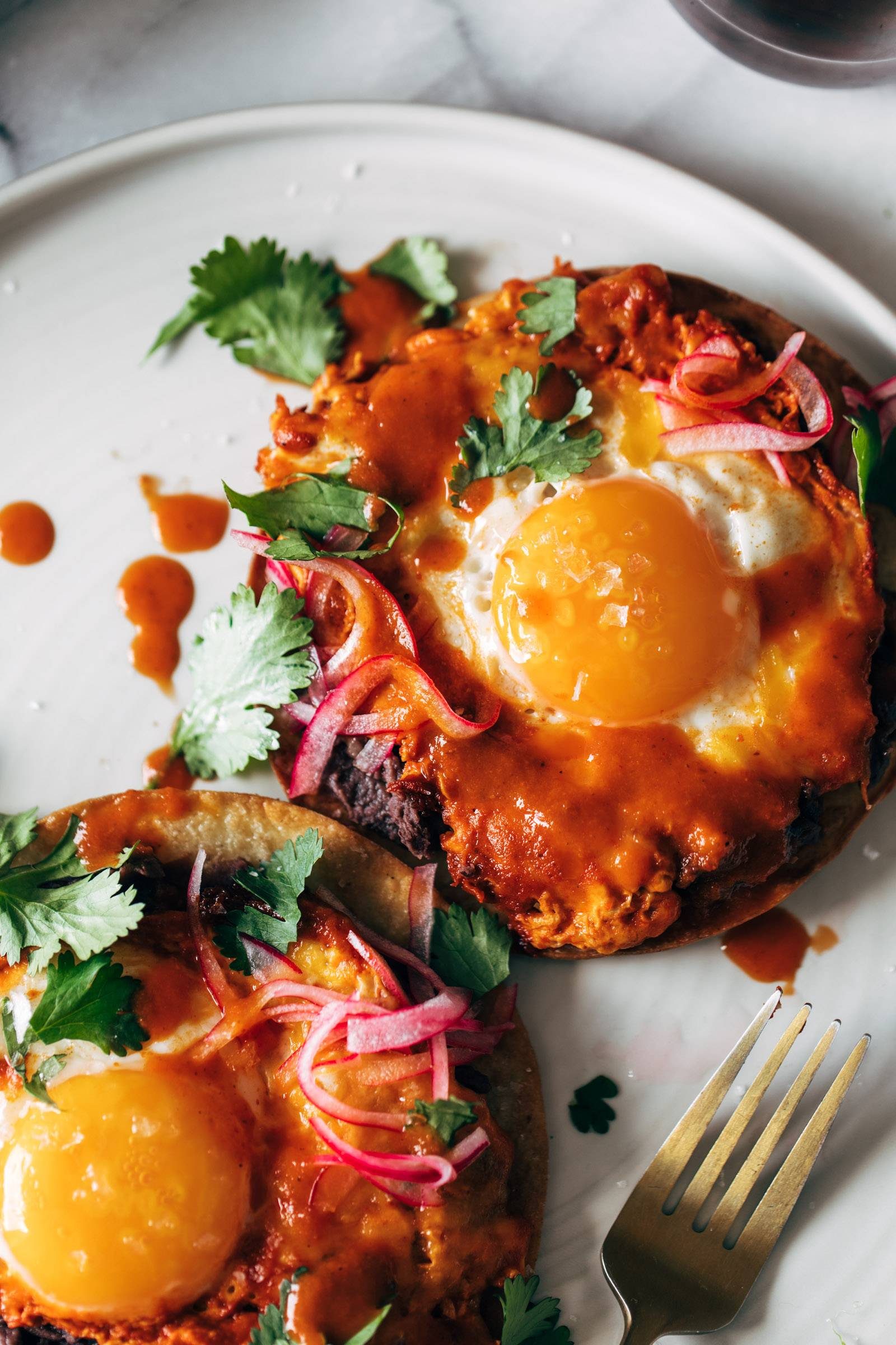 Red chile tostadas with eggs and pickled onions.