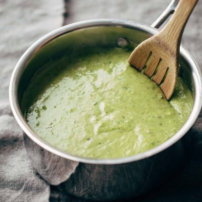 Roasted Poblano Sauce in a pan with a wooden spoon.